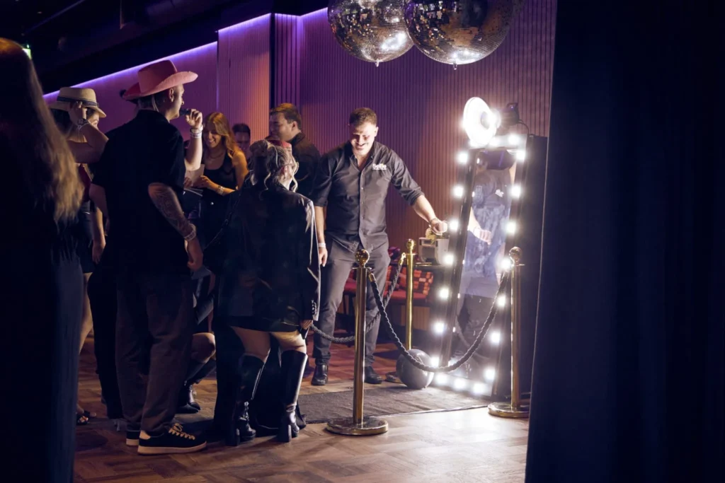 Party scene with magic mirror photo booth and guests