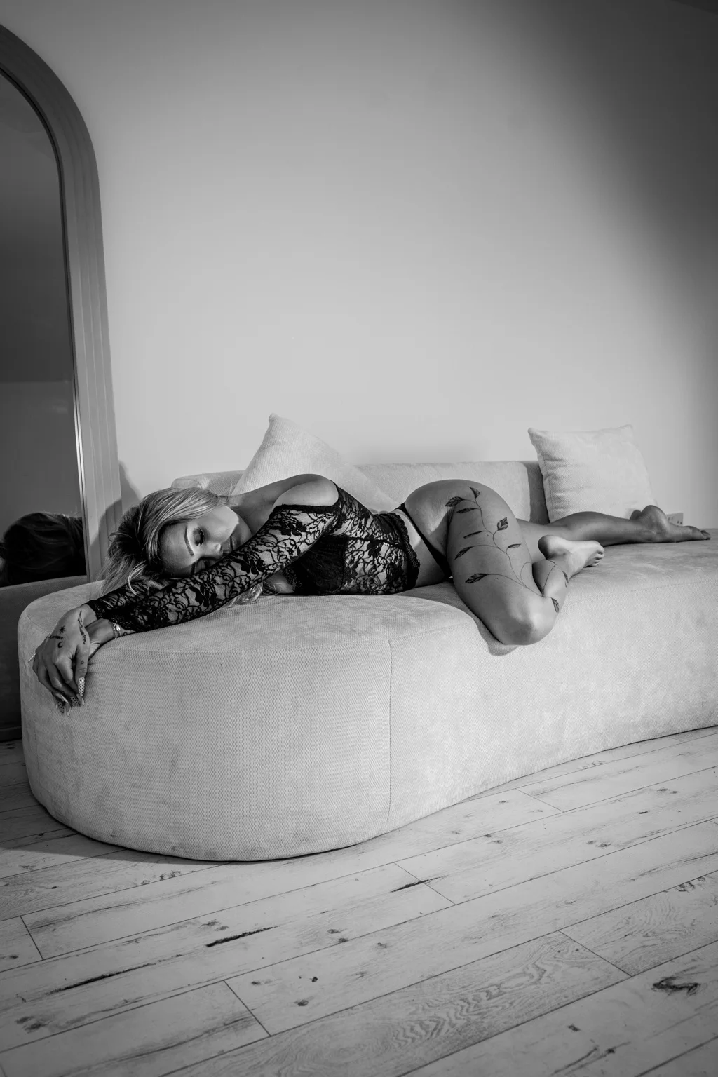 Black-and-white boudoir portrait on the cream sofa