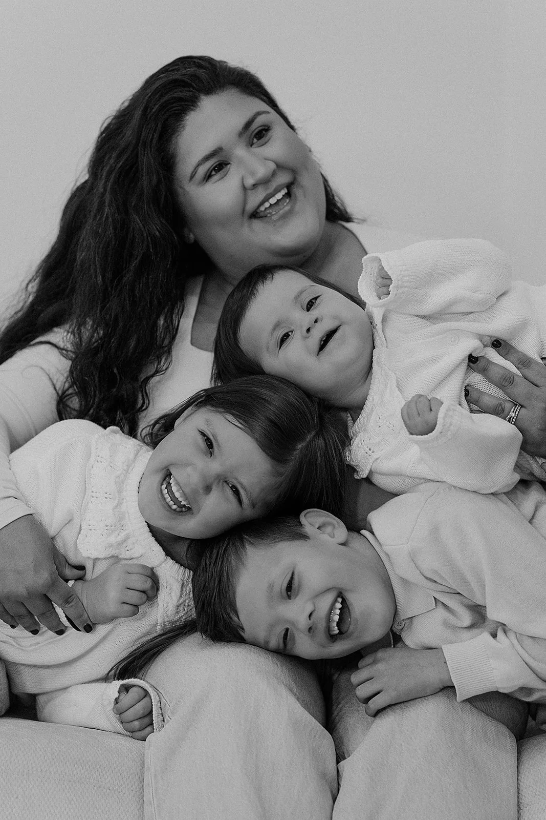 Black and white family portrait of a mother with three children