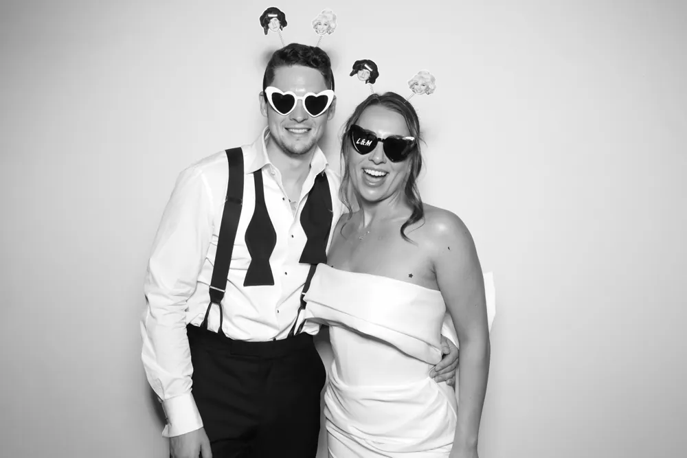 Bride and groom enjoying their black-and-white wedding photo booth