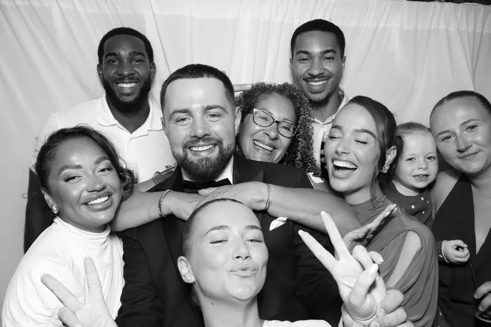 A family group enjoying a black-and-white photo booth portrait