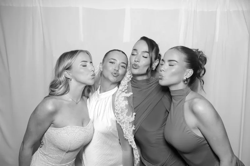 Four guests enjoying a black-and-white Selfie Glam Booth portrait