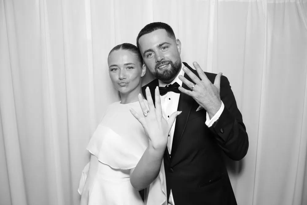 Newlyweds showing their wedding rings in a Glam Booth portrait