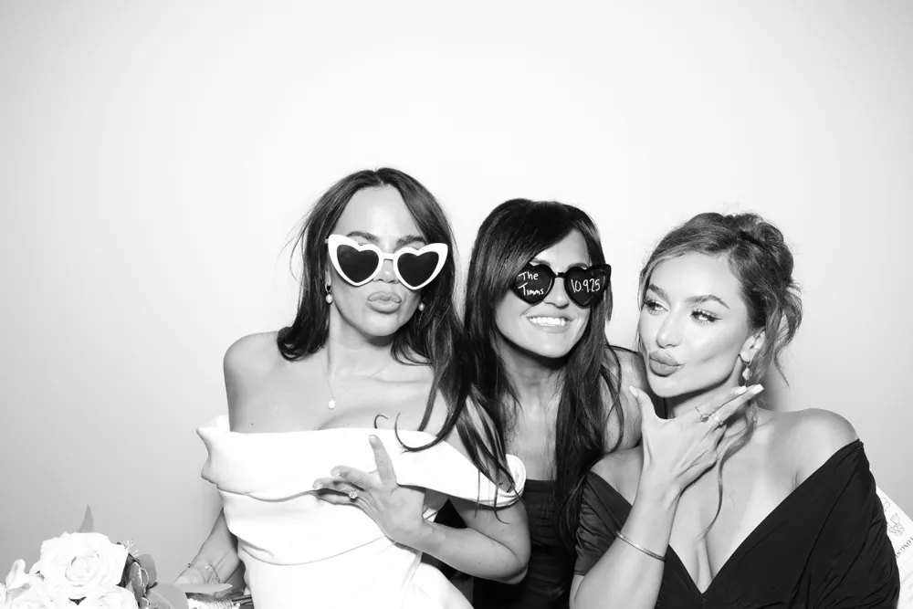 Three wedding guests posing for a monochrome portrait