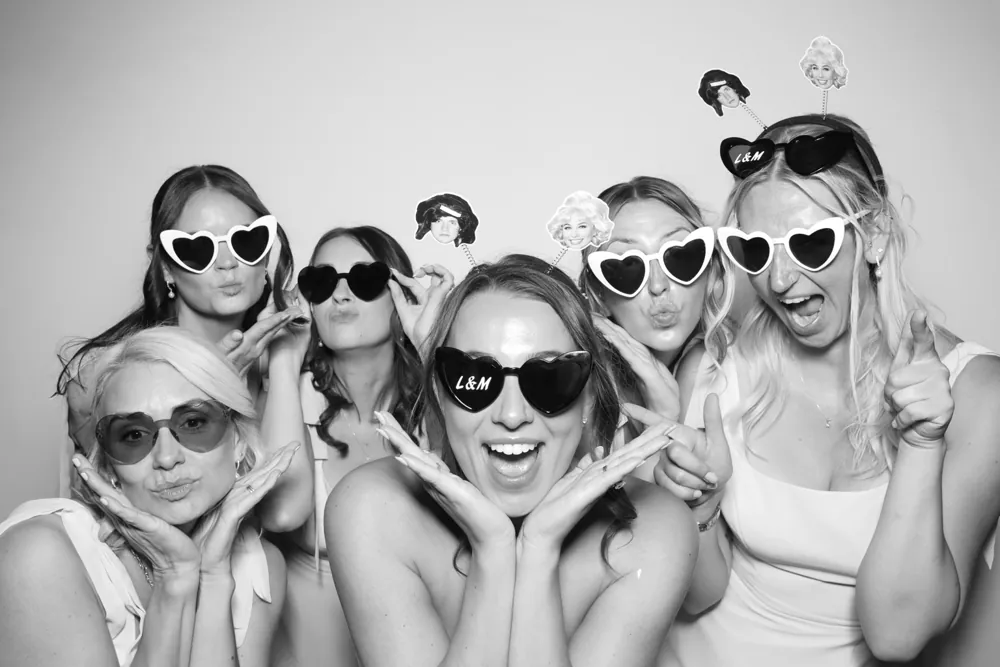 Wedding guests wearing heart-shaped glasses in the Selfie Glam Booth
