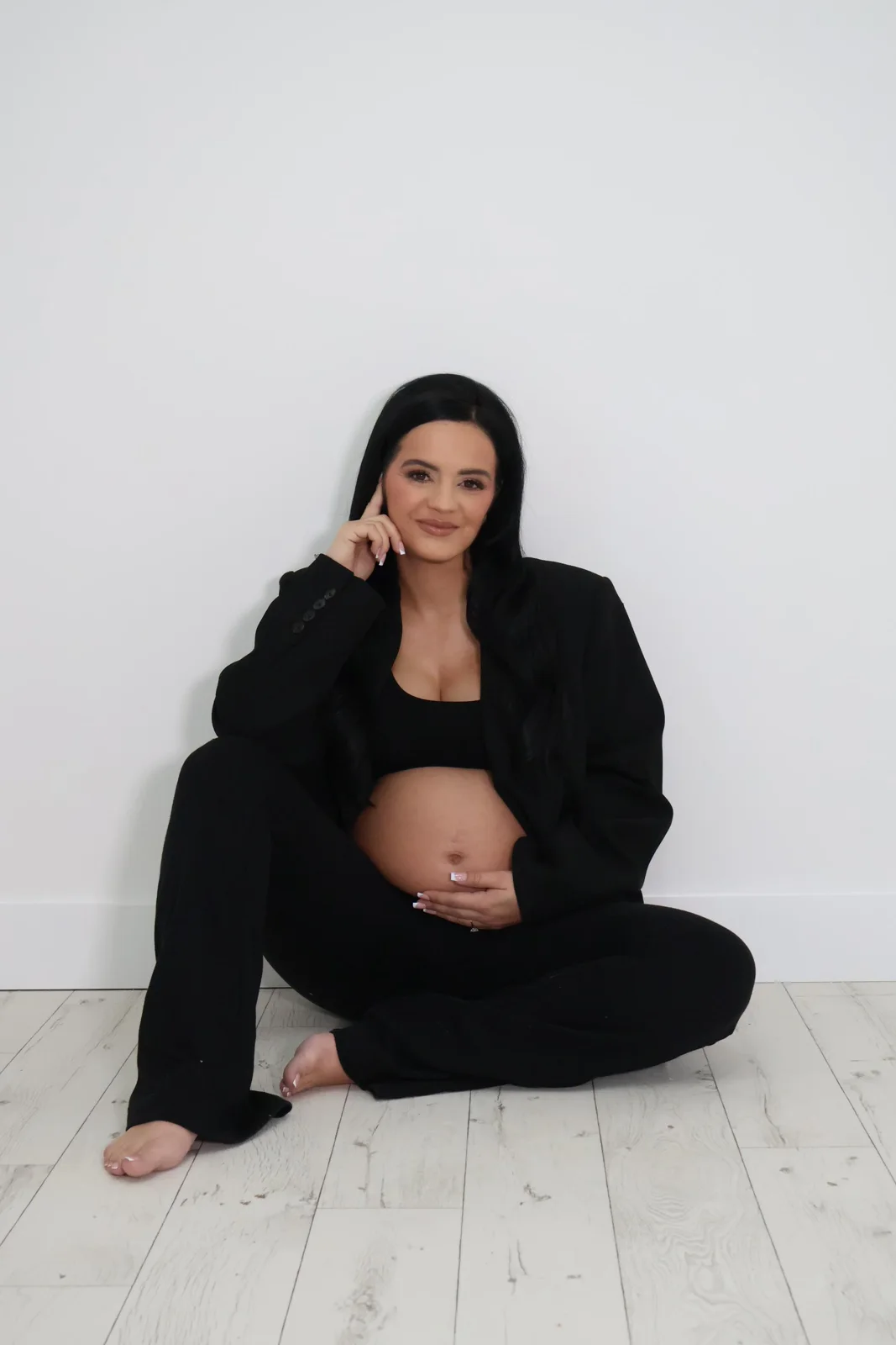 Seated maternity portrait in a black suit
