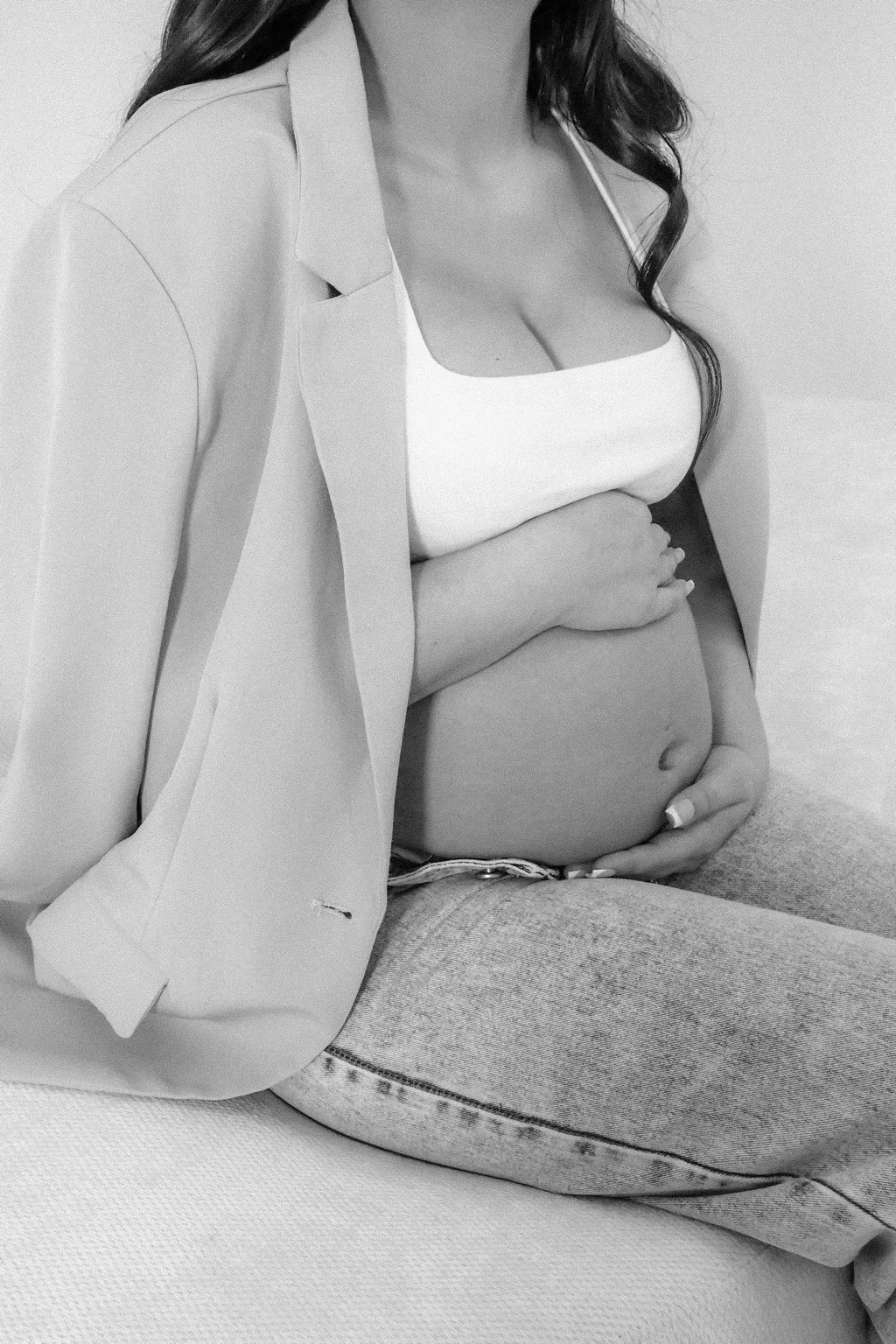 Black-and-white maternity detail portrait on the cream sofa