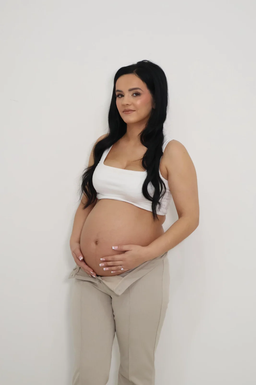 Maternity portrait with white top and neutral trousers