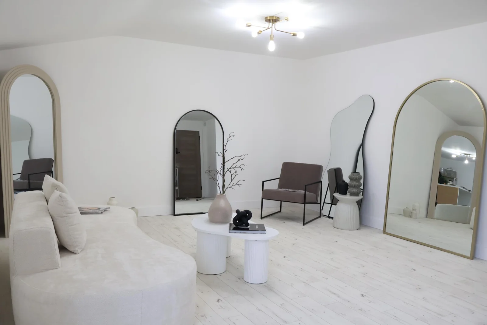 Wide view of the studio with cream sofa, mirrors and styled shooting areas