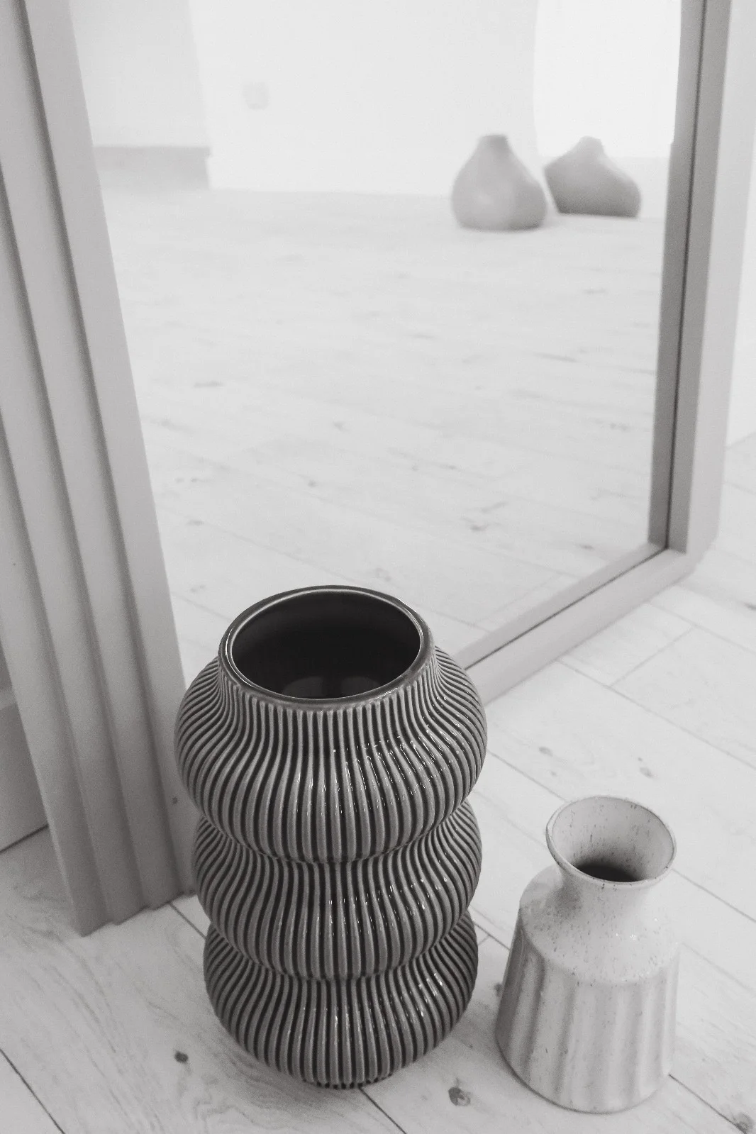 Sculptural vases and mirror detail in black and white